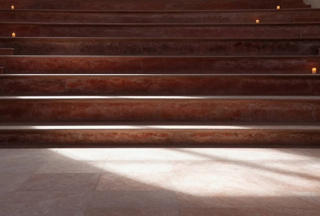 Ein leerer antiker Hörsaal aus Stein mit ansteigenden Sitzreihen im späten Nachmittagslicht, lange Schatten fallen über den Boden